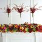 Red orchid vases on altar hedge